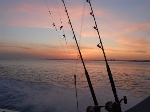 Sunset, Boat Wake, and Fishing Poles